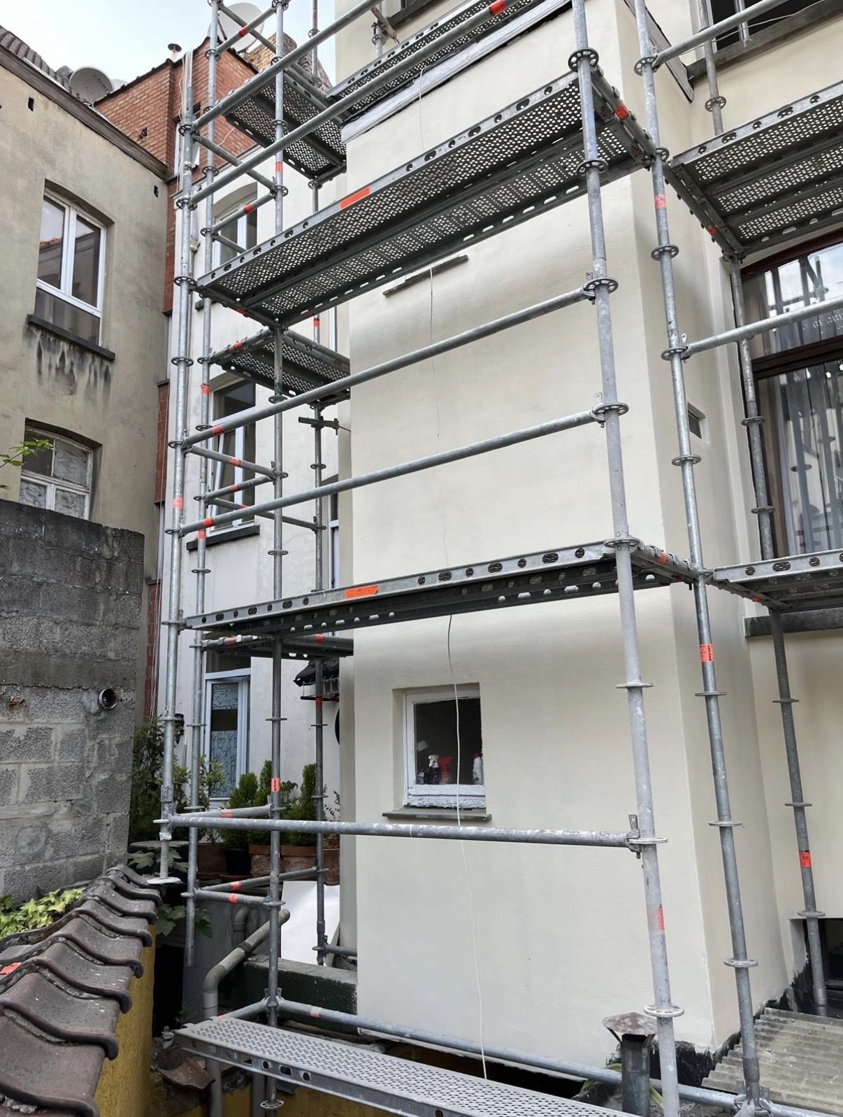 Façade en cours — échafaudage et crépi arrière