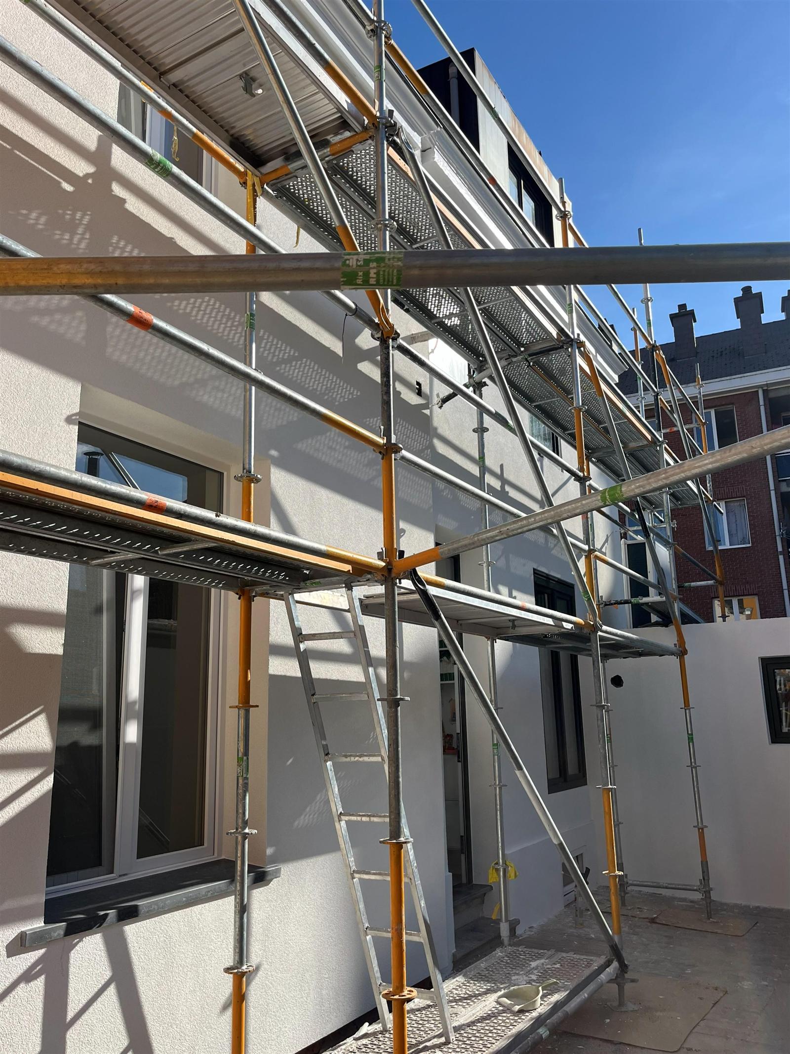 Façade en cours — application du crépi blanc