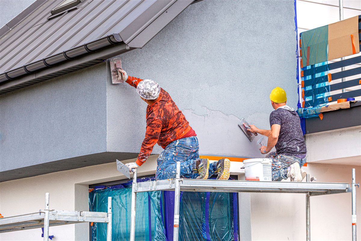 Ouvriers appliquant le crépi sur façade